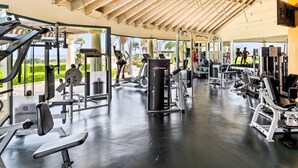 A gym with various exercise equipment, large windows, and a high ceiling. - Spacious 3BR Villa Retreat for 6 Guests & 3.5 Baths at Mesa Vista 26 by Bocobay (Noord)