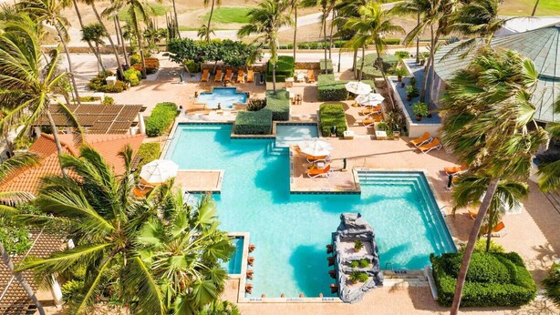 A resort pool area with multiple swimming pools, palm trees, and lounge chairs. - Spacious 3BR Villa Retreat for 6 Guests & 3.5 Baths at Mesa Vista 26 by Bocobay (Noord)