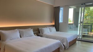 A hotel room with two beds, a large sliding glass door to a balcony, and a modern design. - Orange Homestay (Kaohsiung)