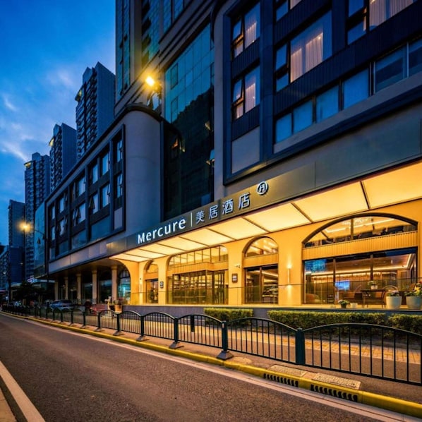 A hotel with a modern facade, a prominent entrance, and a well-lit exterior.