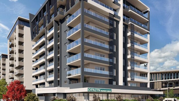 A multi-story residential building with balconies, a flat roof, and a sign for Opalyn Property Group.