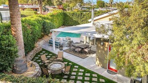A patio area with a pool, outdoor furniture, and a pergola.