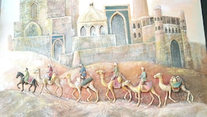 A mural of camels and riders on a desert landscape with a castle in the background. - Elegant Hotel (Tashkent)