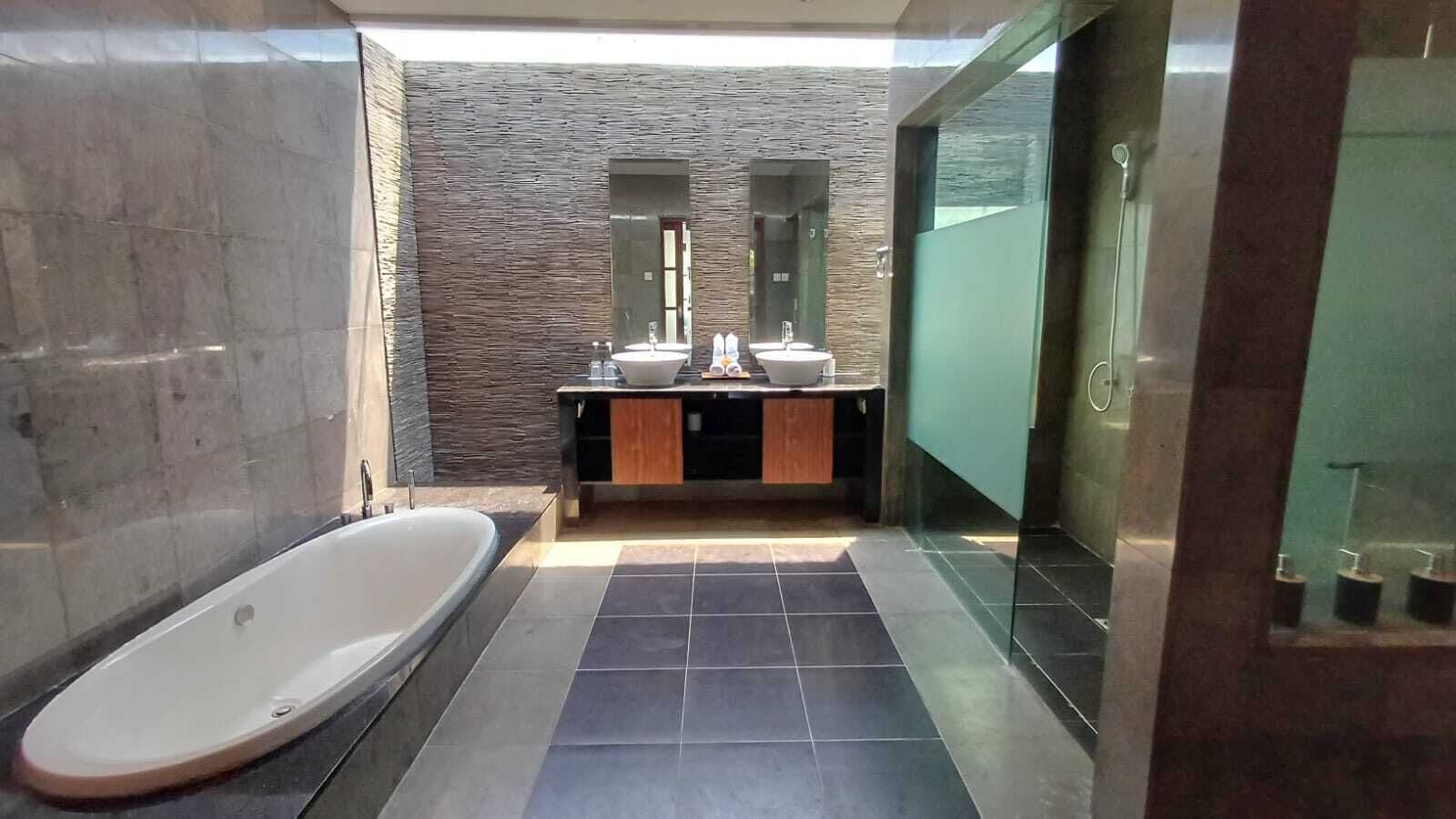 A modern bathroom with a freestanding bathtub, a vanity with a mirror, and a shower area.