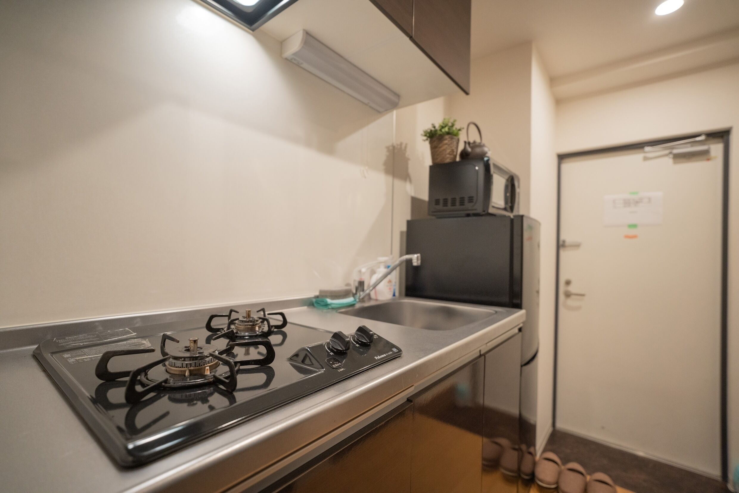 A kitchen with a gas stove, a sink, and a cabinet.