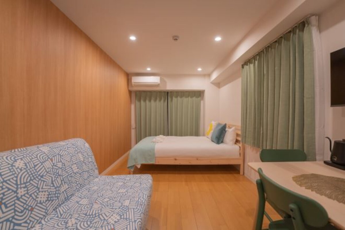 Ein Schlafzimmer mit einem Bett, einem Schlafsofa, einem Schreibtisch und einem Sessel.