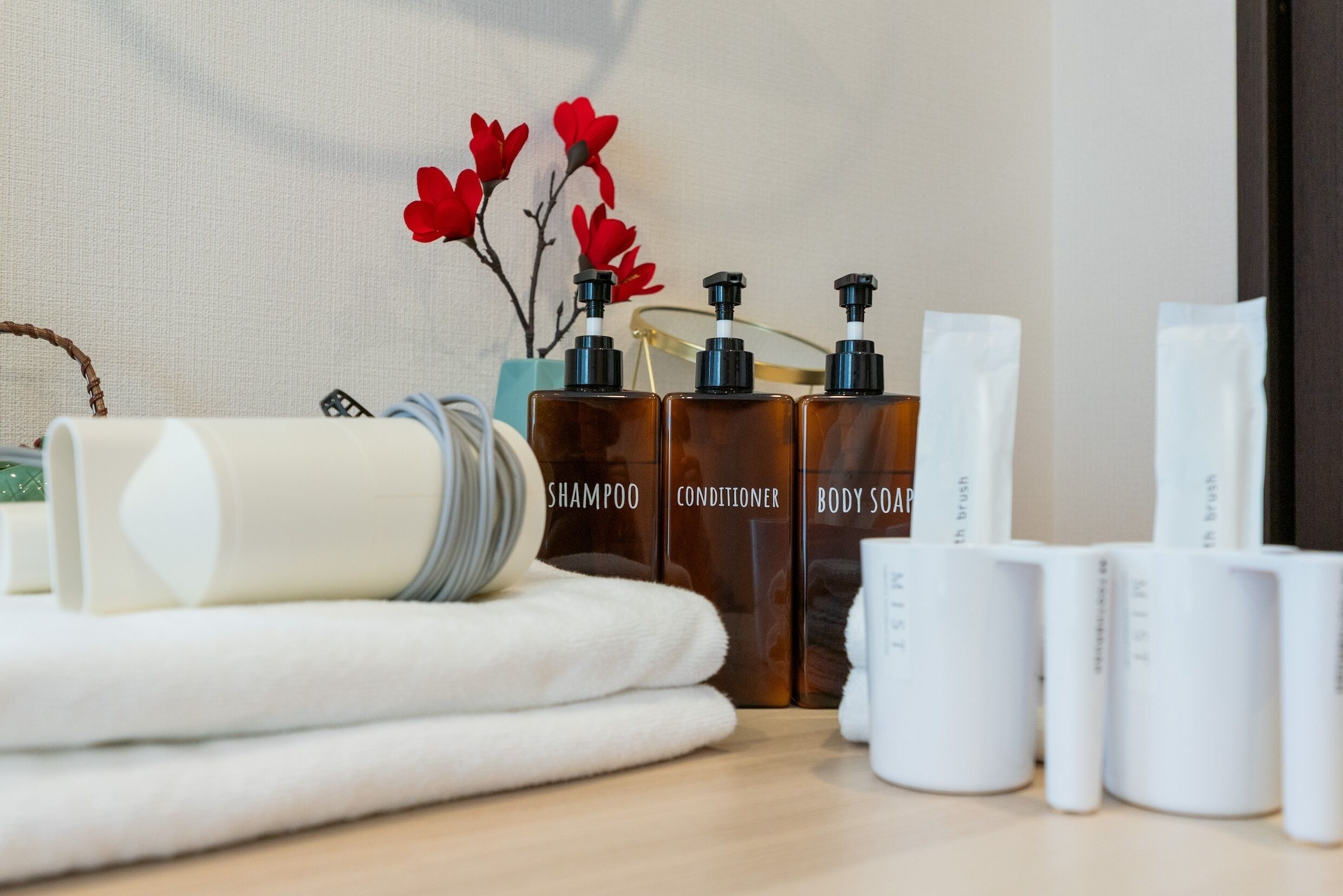 Een badkamer met toiletartikelen, zoals shampoo, conditioner en douchezeep, gerangschikt op een houten oppervlak.