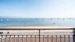 Une plage avec une promenade en bois et une rambarde au premier plan.