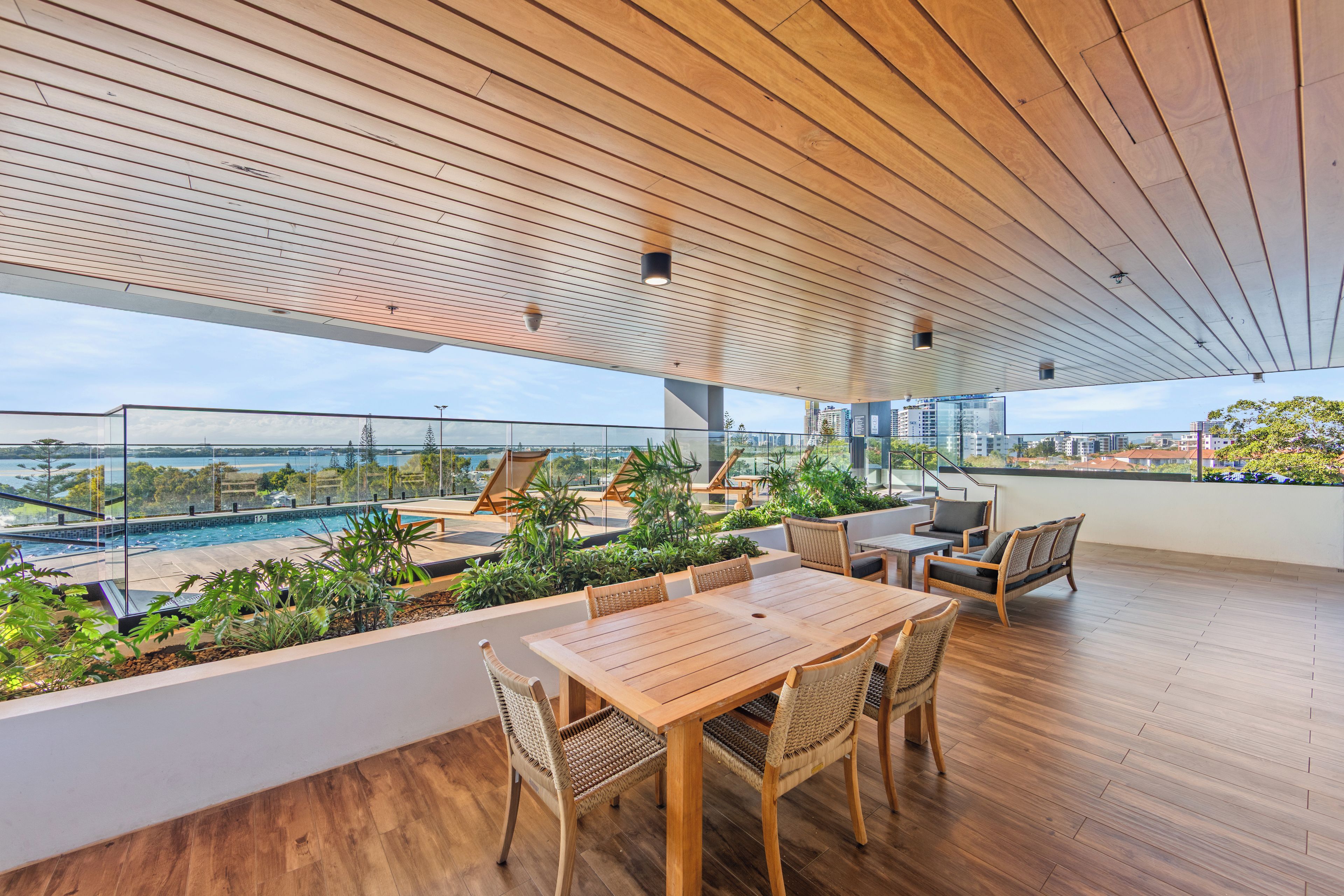 Une terrasse sur le toit avec une piscine, un plancher en bois et du mobilier d’extérieur.