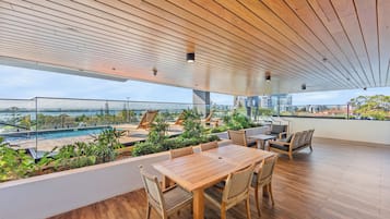 Une terrasse sur le toit avec une piscine, un plancher en bois et du mobilier d’extérieur.