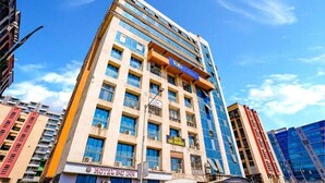 A multi-story hotel with a prominent sign for 'HOTEL BIKE MANZAT' and 'HOTEL LAGOON'. - Diamond By Glitz Hotels (Mumbai)