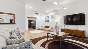 Ein modernes Wohnzimmer mit einer Couch, einem Couchtisch und einem Fernseher.