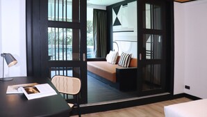 Une chambre d’hôtel moderne, équipée d’un lit, d’un bureau avec une lampe et d’une chaise.