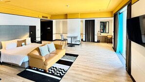 Una habitación de hotel moderna con cama, sofá, escritorio y televisor.
