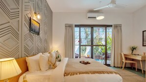 Habitación de hotel moderna con una cama grande, un escritorio y vistas al exterior.