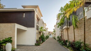 Edificio residencial con un patio central, que cuenta con un camino pavimentado y zonas verdes circundantes.
