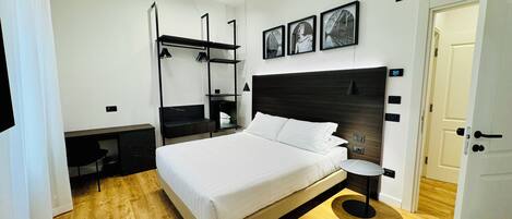 Un dormitorio moderno con una cama grande, un escritorio y un armario empotrado.