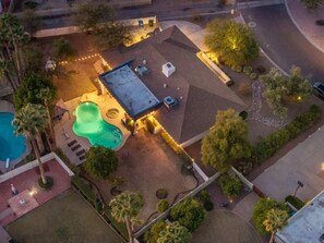 An aerial view of a property with a swimming pool, patio area, and a covered outdoor space.