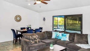 A living room with a sofa, coffee table, and a dining area with chairs and a table. - family Spacious Heated Pool Home 5 Min To Weeki Wachee (Spring Hill)