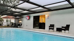 A swimming pool with a covered area, chairs, and a digital display. - family Spacious Heated Pool Home 5 Min To Weeki Wachee (Spring Hill)
