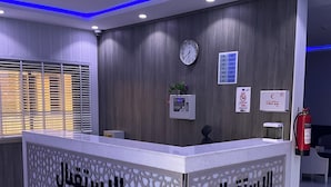 A reception area with a reception desk, a clock, and a first aid sign on the wall.