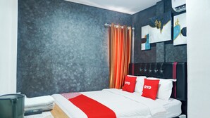 A modern hotel room with a bed, a desk, and a chair. - Hotel O Bandar Lampung Near Gor Saburai Formerly Omah Anakku (Bandar Lampung)