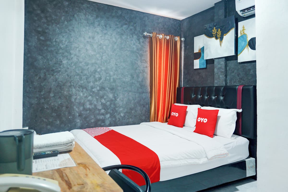 Ein modernes Hotelzimmer mit Bett, Schreibtisch und Stuhl.