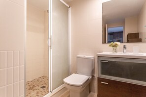 A bathroom with a shower, toilet, sink, and mirror. - Kandinsky apartment with sea view (L'Escala)
