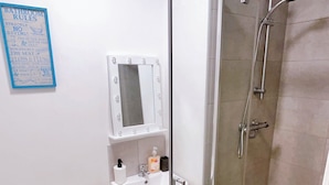 A bathroom with a toilet, sink, mirror, and glass-enclosed shower. - Room-one Studio Bradford City Center (Bradford)