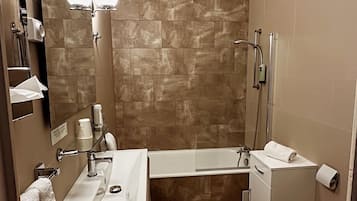 A modern bathroom with a bathtub, toilet, and sink.