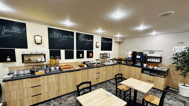 A modern café with a wooden counter, black chalkboard signs, and a variety of food and drink options. - Logis Hôtel le Passiflore (Chateaubernard)