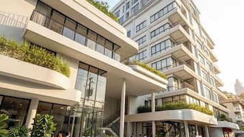 A multi-story building with a modern architectural design, featuring balconies and large windows.