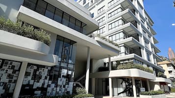A modern multi-story building with a flat facade, large windows, and balconies.