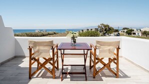 Une terrasse avec une table et deux chaises, offrant une vue sur la côte.