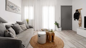Un salon moderne avec un canapé gris, une table basse ronde et une porte grise.