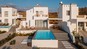 Una villa moderna con piscina, area salotto esterna e vista sul paesaggio.