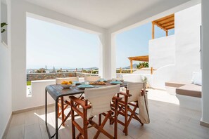 Un ampio balcone con tavolo in legno apparecchiato per mangiare, con vista panoramica.