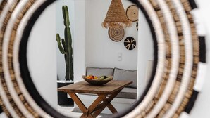A circular view of a room with a cactus, woven wall hanging, and a bowl of fruit on a wooden table.
