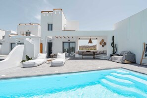 A modern poolside area with a pool, white walls, and a seating area with a view of the landscape. - Villa Isola , Plaka area , Naxos (Naxos)