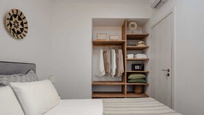 Un dormitorio con cama, un armario con estantes y un adorno en la pared.