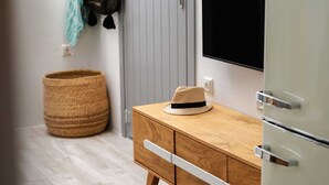 Un mueble de madera con cajones, una cesta tejida y un sombrero encima.