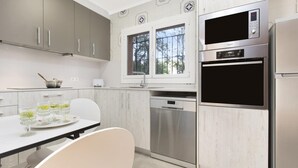 A modern kitchen with grey cabinets, a stainless steel refrigerator, a built-in oven, and a dishwasher. - Can Benet Pl in Calella de Palafrugell (Palafrugell)