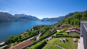 A lakeside property with a view of the lake, mountains, and a well-maintained garden. - Casa Laura Apt 6 in Il Piazzo (Plesio)