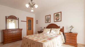 A bedroom with a large bed, a dresser, a nightstand, a mirror, and two framed pictures on the wall. - El Descanso in Mijas (Mijas)