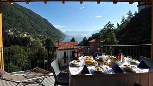 Una mesa de comedor en un balcón con vistas panorámicas a la montaña.
