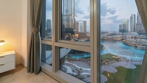 A room with a large window overlooking a cityscape and a waterfront area. - Iconic Views -Burj Khalifa & Fountain Views (Dubai)