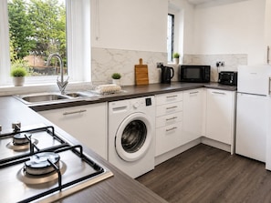 A modern kitchen with a built-in washer, a microwave, and a stove.