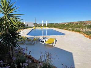 A swimming pool with sun loungers and a stone patio. - Orange Grove Residence (Silves)