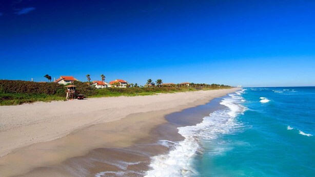 A beach with houses and a lifeguard tower. - Beachy Retreat 1 Mile to Beach (Satellite Beach)