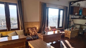A cozy living room with a sofa, a wooden coffee table, and a patterned rug. - Mount Vista Leh (Leh)